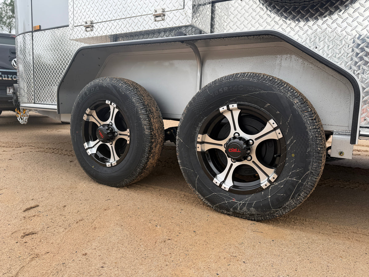 Close-up of a float's tandem wheels and tyres standing on sand