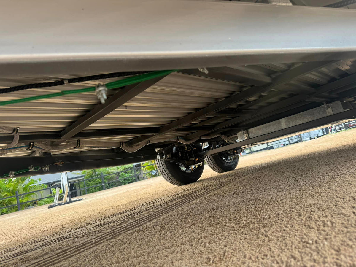 Low view under a horse float, showing the axles, wheels and chassis