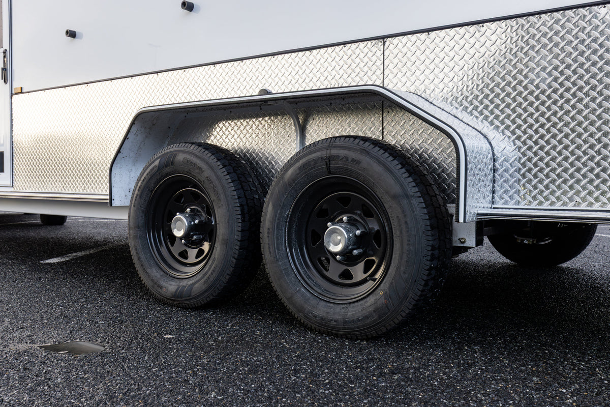 Tandem axle wheels and tyres under a float with chequer-plate guards