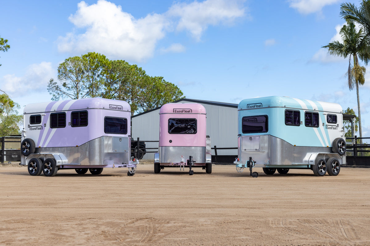 Three pastel EuroFloat horse floats parked side by side