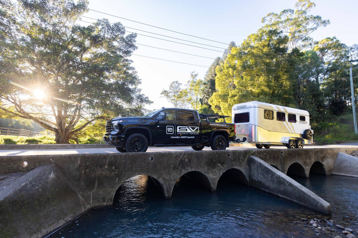 Silverado HD towing a EuroFloat over a bridge at sunrise